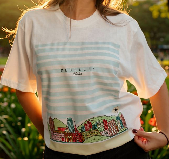 Person wearing a t-shirt with a graphic design and 'Medellín' text, standing outdoors.